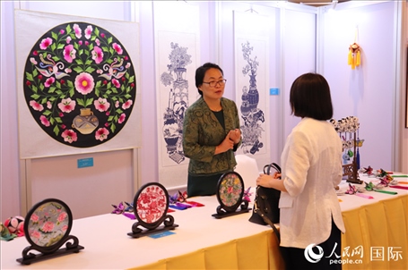 青海非遺文化傳承人向嘉賓介紹展品。人民網(wǎng)實習(xí)生姚欣可攝