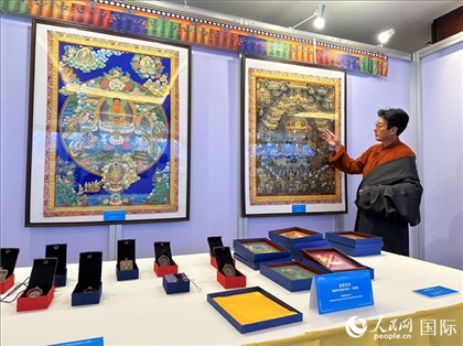 熱貢藝術(shù)國家級代表性傳承人夏吾角向嘉賓介紹作品。人民網(wǎng)記者 簡承淵攝