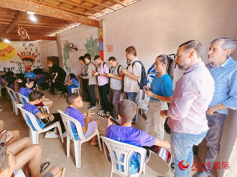  受益于中國企業(yè)的“青少年成長”項目，700多名當(dāng)?shù)厍嗌倌甑囊魳泛妥闱驂粝氩迳狭顺岚?。圖為聯(lián)合采訪團(tuán)正在采訪參加音樂培訓(xùn)的孩子們。 人民網(wǎng)記者 陳一鳴攝