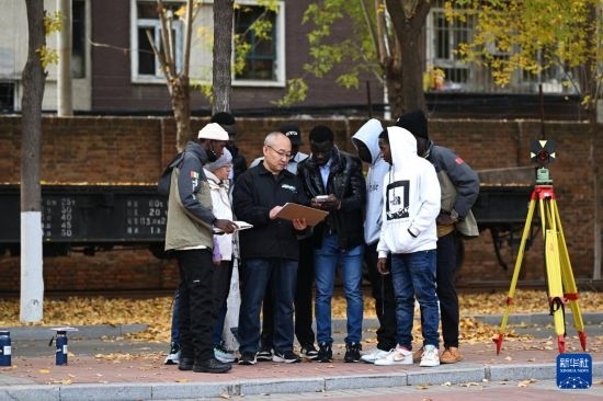 在天津鐵道職業(yè)技術(shù)學院，老師指導幾內(nèi)亞學員使用測距儀器（11月11日攝）。新華社記者 李然 攝