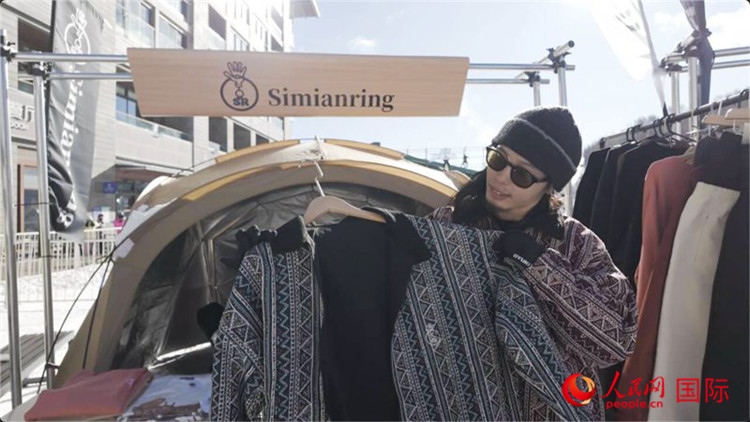 藤田周正在展示自己設(shè)計(jì)的滑雪服。人民網(wǎng)記者 袁蒙攝