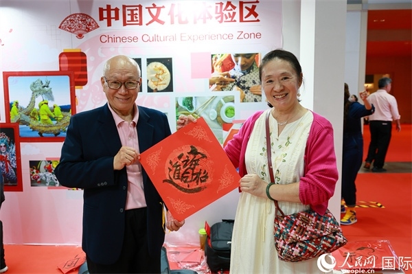 本地觀眾在中國文化體驗區(qū)展示書法作品。人民網(wǎng)記者 白元琪攝