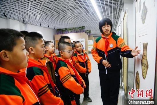 圖為學(xué)生通過(guò)展板了解出土于青海省海東市樂(lè)都區(qū)的辛店文化文物鹿紋彩陶甕。中新社記者 馬銘言 攝