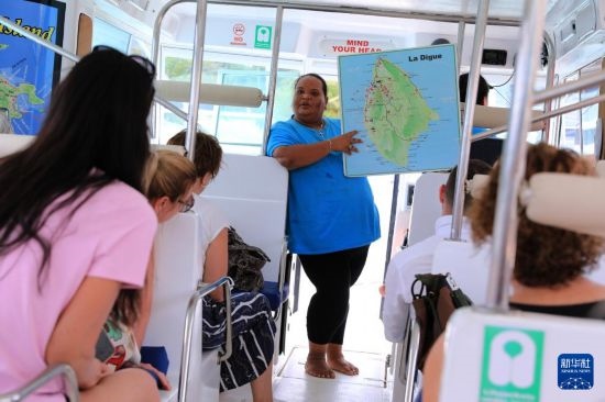 3月15日，一名導(dǎo)游在游艇上為游客介紹塞舌爾拉迪格島。新華社記者 董江輝 攝