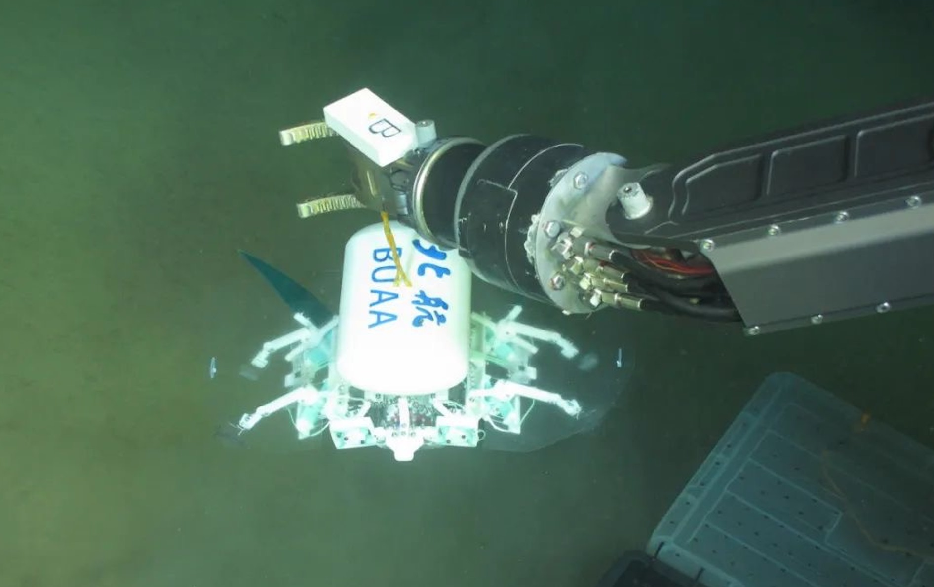 科研人員利用機(jī)械臂將北航深海小型機(jī)器人投于馬里亞納海溝。校方供圖