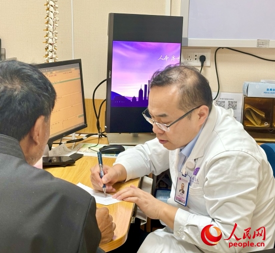 路桂軍接診時為患者寫下用藥提示。人民網(wǎng)記者 金慧慧攝