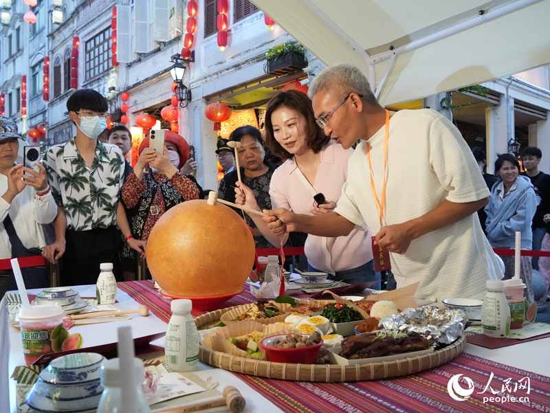 嘉賓品嘗海南傳統(tǒng)美食“煎堆”。人民網(wǎng)記者 張力洋攝