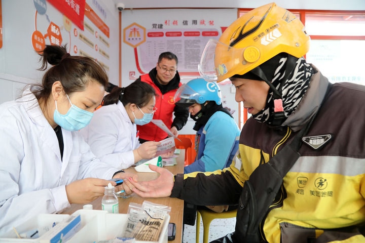 2025年3月5日，志愿者在山東省棗莊市市中區(qū)一工會(huì)驛站為外賣員免費(fèi)測(cè)量血糖。新華社發(fā)（王海楠攝）