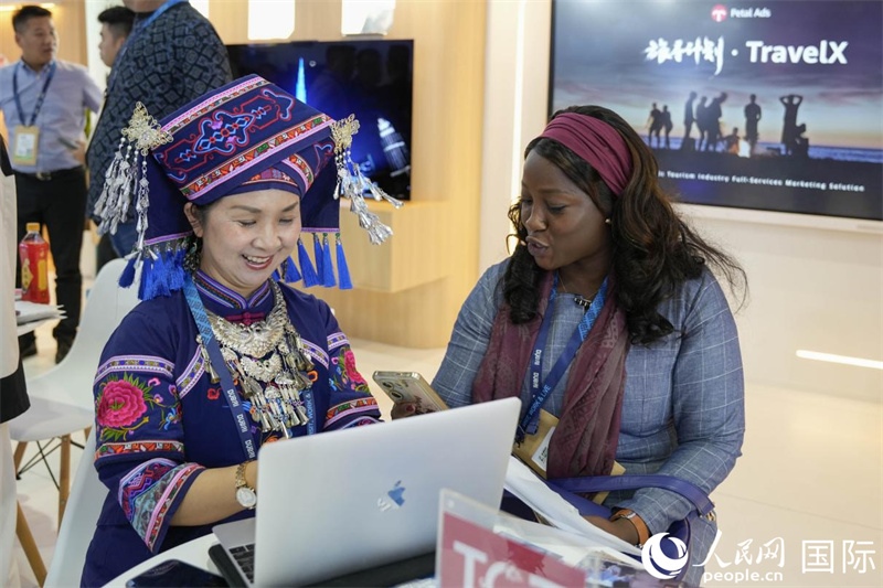 來自廣西的旅游業(yè)者同客戶交流。人民網(wǎng)塔里克·易卜拉欣攝