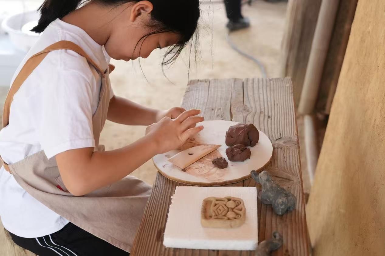 游客制作良渚特色陶藝品。良渚博物院供圖