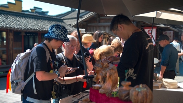 “五一”期間，游客正在烏鎮(zhèn)“水鄉(xiāng)碼頭”挑選購(gòu)買(mǎi)文創(chuàng)產(chǎn)品。受訪者供圖