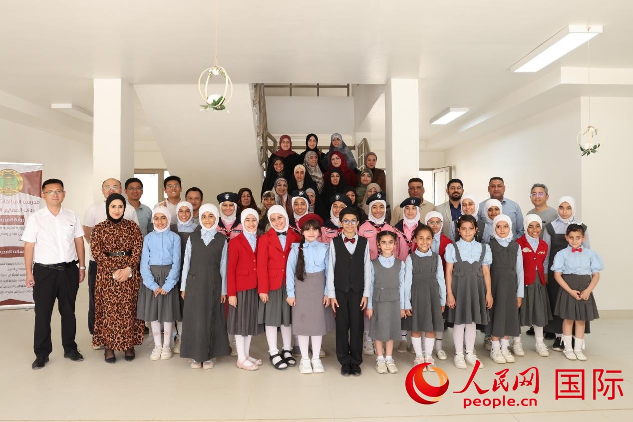 中國電建員工與阿爾穆塔?阿里卡特國際學校的師生及政府官員等合影。人民網(wǎng)記者 薛丹攝
