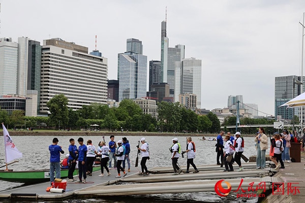 來(lái)自美國(guó)的快樂(lè)龍舟隊(duì)選手們正在登船準(zhǔn)備參賽。人民網(wǎng)記者 劉仲華攝
