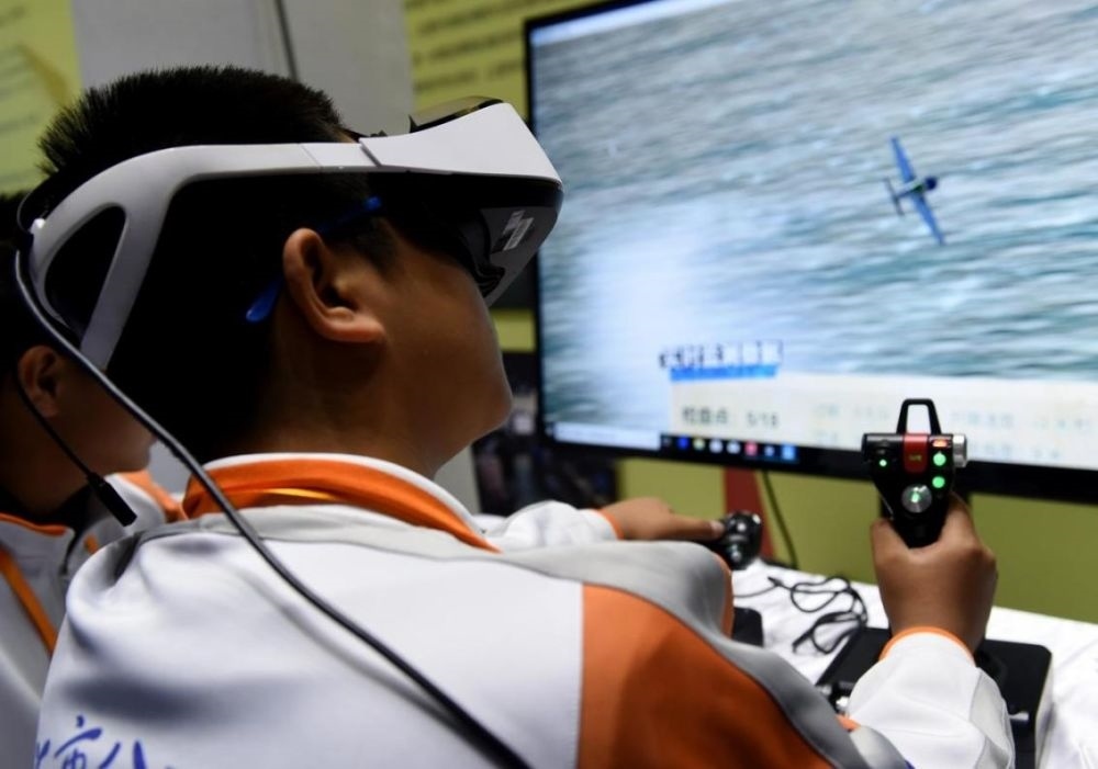 北京市八一學(xué)校的學(xué)生在北京市中小學(xué)生特色科技活動(dòng)展示上體驗(yàn)VR技術(shù)（2018年11月24日攝）新華社記者 羅曉光 攝。