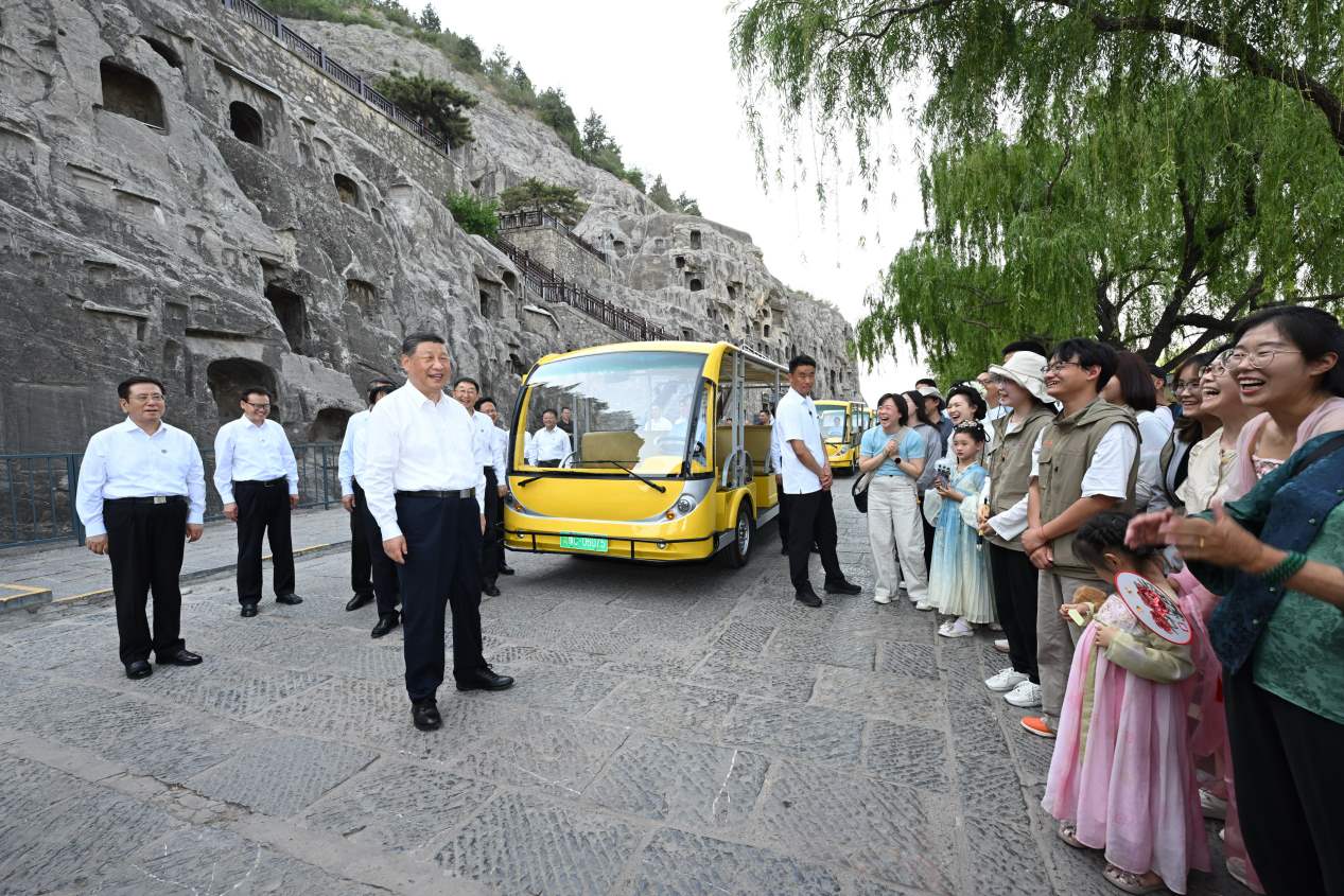 5月19日，習近平在洛陽龍門石窟考察時，同游客親切交流。