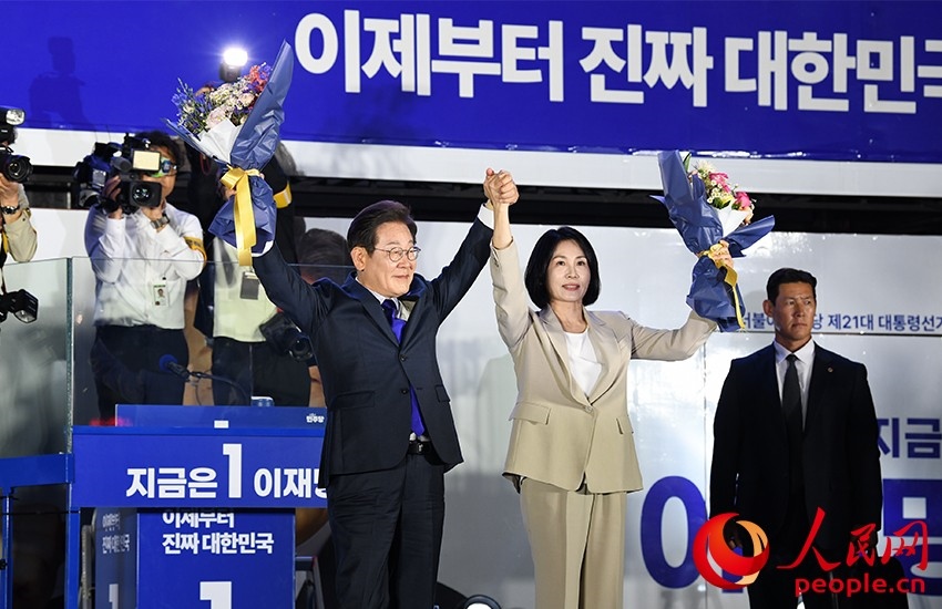 6月4日凌晨，確定當(dāng)選韓國(guó)總統(tǒng)的李在明舉手向歡呼的支持者們致意。 人民網(wǎng) 康炯彬攝