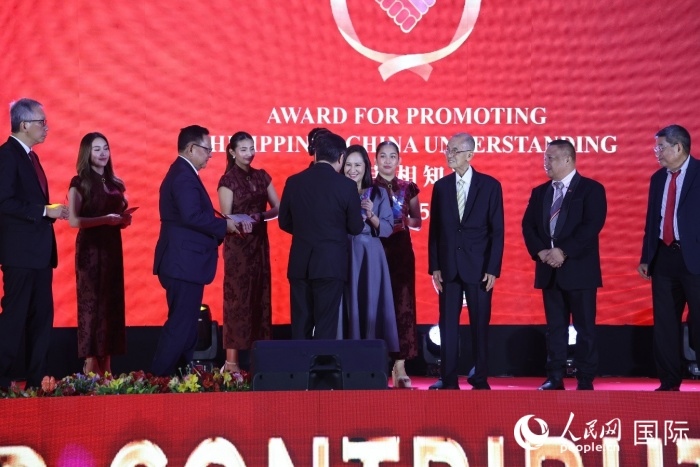 黃溪連大使給榮獲“重要貢獻獎”的奎松市市長喬伊·貝蒙蒂等人頒獎。人民網記者 樊帆攝